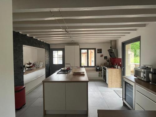 a kitchen with an island in the middle of a room at La Fontaine - Détente - Piscine Jacuzzi - 12p in La Chartre-sur-le-Loir