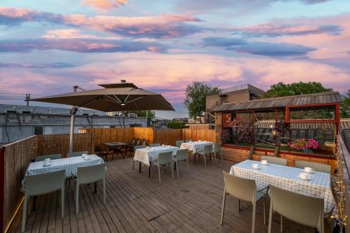 a patio with tables and chairs and an umbrella at Peking Courtyard Qianmen in Beijing