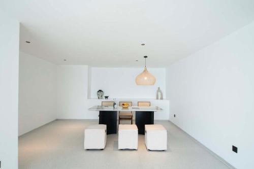 a kitchen with white walls and a table and stools at Shenzhen GuanHu Secret Wild Reef Seaview Hotel in Shenzhen