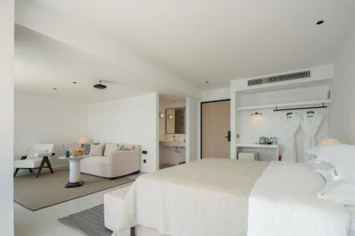 a white bedroom with a white bed and a living room at Shenzhen GuanHu Secret Wild Reef Seaview Hotel in Shenzhen
