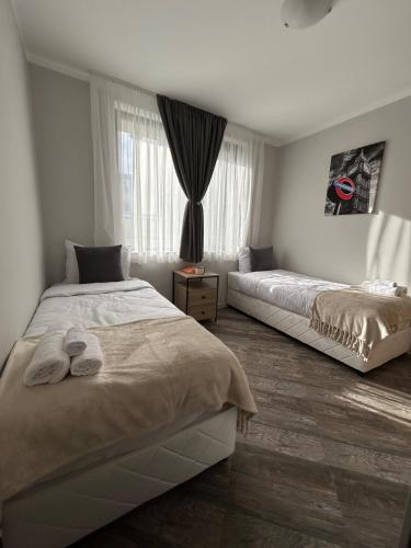 a bedroom with two beds and a window at Tanov Cozy Place in Blagoevgrad