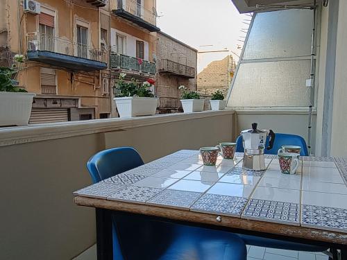 una mesa y sillas en el balcón de un edificio en Gioeni Apartment 95, en Agrigento