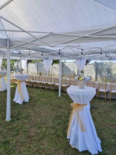 a row of tables and chairs under a tent at Vila La hacienda in Beška