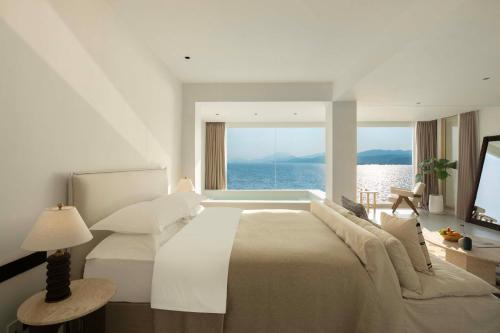 a bedroom with a large bed with a view of the ocean at Shenzhen GuanHu Secret Wild Reef Seaview Hotel in Shenzhen
