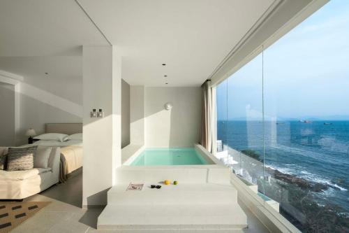 a bedroom with a swimming pool and a bed and a window at Shenzhen GuanHu Secret Wild Reef Seaview Hotel in Shenzhen