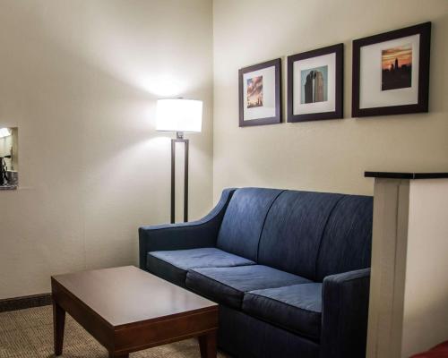 a living room with a blue couch and a lamp at Comfort Suites University - Research Park in Charlotte