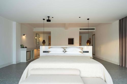 a bedroom with a large white bed with white pillows at Shenzhen GuanHu Secret Wild Reef Seaview Hotel in Shenzhen