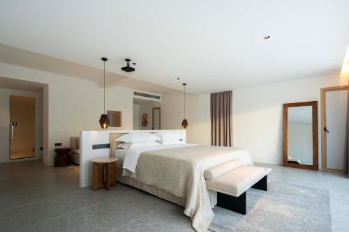 a large white bedroom with a large bed and a chair at Shenzhen GuanHu Secret Wild Reef Seaview Hotel in Shenzhen