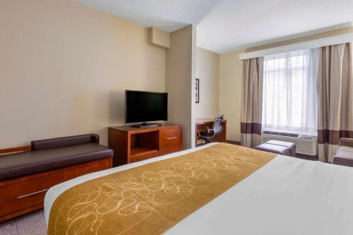 a hotel room with a bed and a flat screen tv at Comfort Suites Boone - University Area in Boone