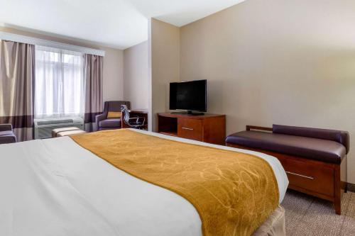 a hotel room with a bed and a flat screen tv at Comfort Suites Boone - University Area in Boone