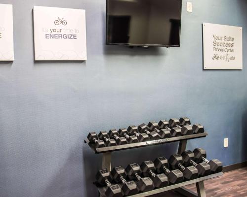 a gym with rows of dumbbells on a wall at Comfort Suites University - Research Park in Charlotte