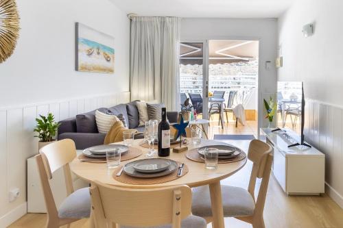 a dining room and living room with a table and chairs at Casa Bettì - Canaima, Puerto Rico in Puerto Rico de Gran Canaria