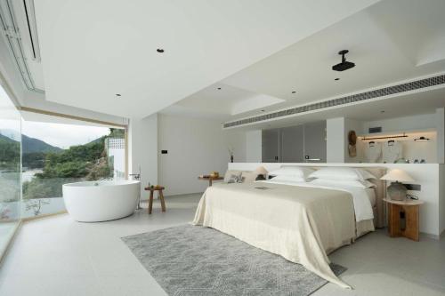 a bedroom with a large bed and a bath tub at Shenzhen GuanHu Secret Wild Reef Seaview Hotel in Shenzhen