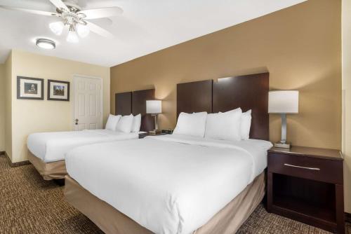 two beds in a hotel room with white sheets at Comfort Inn & Suites Lake Norman in Cornelius