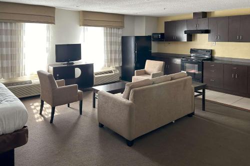 a living room with two chairs and a kitchen at Sleep Inn Wilson near I-95 in Wilson