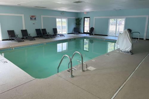 a large swimming pool with chairs in a room at Sleep Inn Wilson near I-95 in Wilson