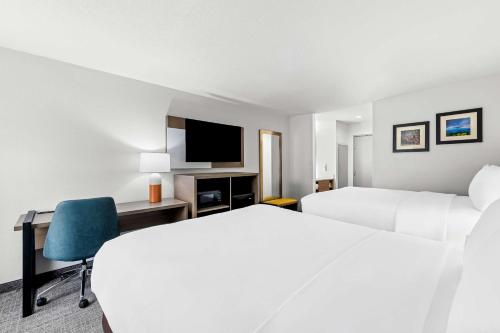 a hotel room with two beds and a desk and a tv at Comfort Inn near Great Smoky Mountain National Park in Maggie Valley