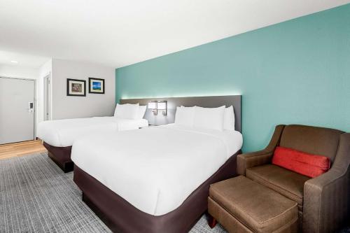 a large bed and a chair in a hotel room at Comfort Inn near Great Smoky Mountain National Park in Maggie Valley