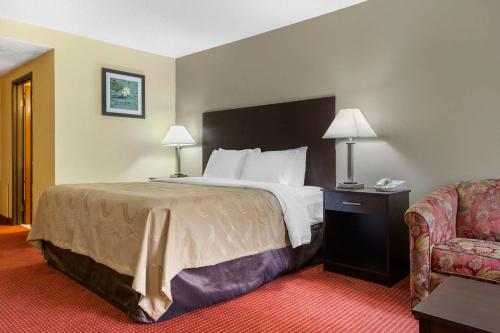 a hotel room with a bed and a chair at Quality Inn Williamston in Williamston