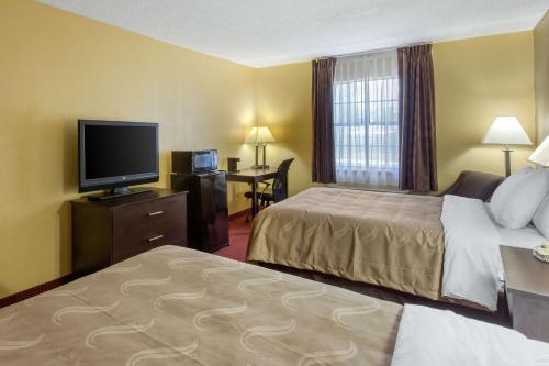a hotel room with two beds and a flat screen tv at Quality Inn Williamston in Williamston