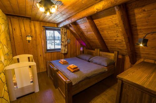 a bedroom with a bed in a wooden cabin at Ranch Jestřebice in Heřmaničky