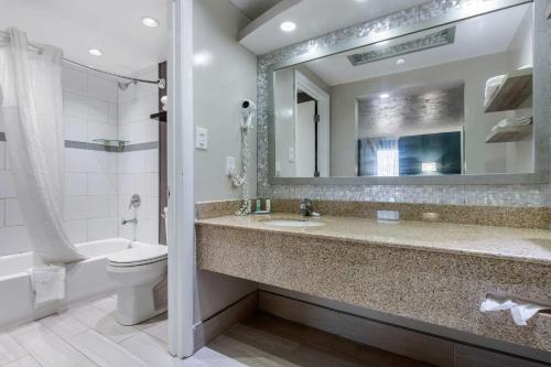 un bagno con lavandino, water e specchio di Quality Inn Carolina Oceanfront a Kill Devil Hills