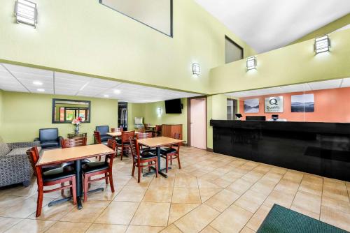 a restaurant with tables and chairs and a piano at Quality Inn Selma - Smithfield in Selma