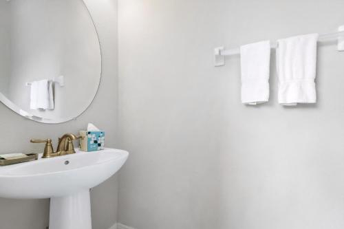 ein weißes Badezimmer mit Waschbecken und Spiegel in der Unterkunft Marvelous Home With Private Pool And Waterpark & Resort Access Near Disney At Encore Resorts Reunion - 7464Mr in Kissimmee