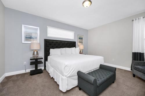 ein Schlafzimmer mit einem großen weißen Bett und einem Stuhl in der Unterkunft Marvelous Home With Private Pool And Waterpark & Resort Access Near Disney At Encore Resorts Reunion - 7464Mr in Kissimmee