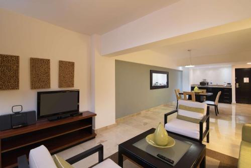 a living room with a flat screen tv and a table at Radisson Hotel Santo Domingo in Santo Domingo