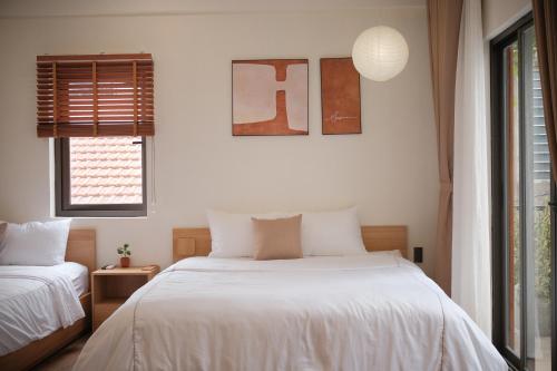 a bedroom with two beds and a window at Glory 2 Hue Homestay in Hue
