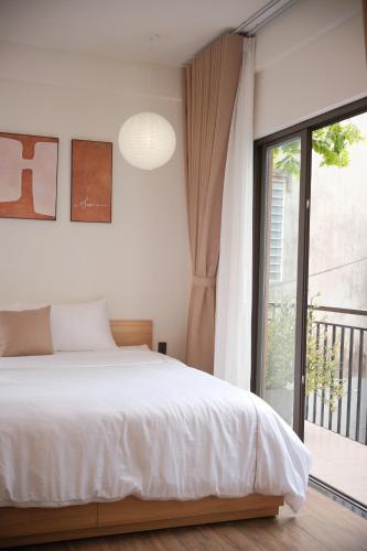 a bedroom with a bed and a large window at Glory 2 Hue Homestay in Hue