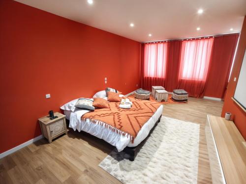 a bedroom with a large bed with orange walls at Studio Chic N2 avec Jacuzzi in Roubaix