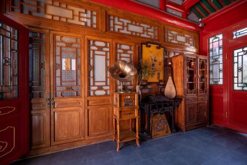 a room with wood paneled walls and a table and a guitar at Peking Courtyard Qianmen in Beijing
