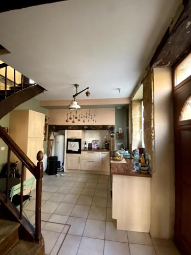 une grande cuisine avec un comptoir et un escalier dans l'établissement House with good energy, à Marminiac