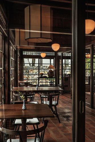 a restaurant with wooden tables and chairs and windows at Lijiang Old Town Lanshe hotel in Lijiang