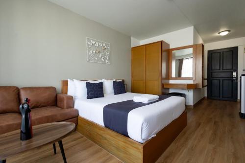 a bedroom with a bed and a couch at Nature Boutique Hotel Ratchayothin in Bangkok