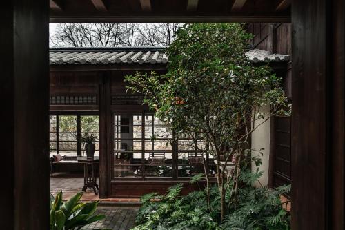 an open door to a patio with a tree at Lijiang Old Town Lanshe hotel in Lijiang