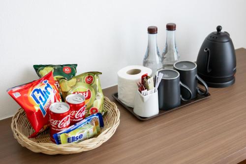 a basket of snacks and drinks on a table at Nature Boutique Hotel Ratchayothin in Bangkok