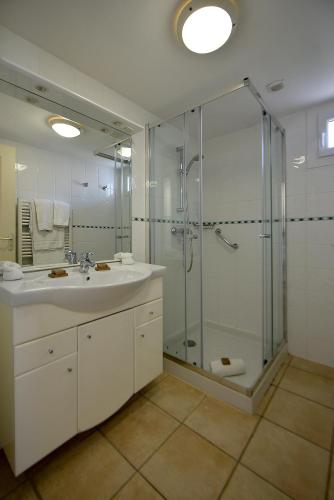 une salle de bain avec une douche en verre et un lavabo dans l'établissement Santa Giulia - Le village de L'hacienda, à Porto-Vecchio