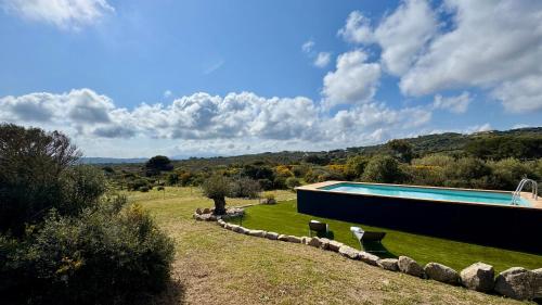 a house with a swimming pool in a field at Villa Magdala in La Maddalena