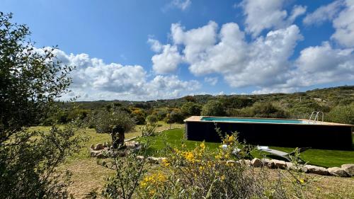 a house in a field with a swimming pool at Villa Magdala in La Maddalena