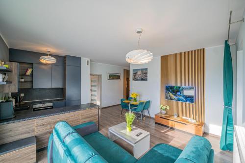 a living room with a blue couch and a table at Apartament w Cieplicach in Jelenia Góra