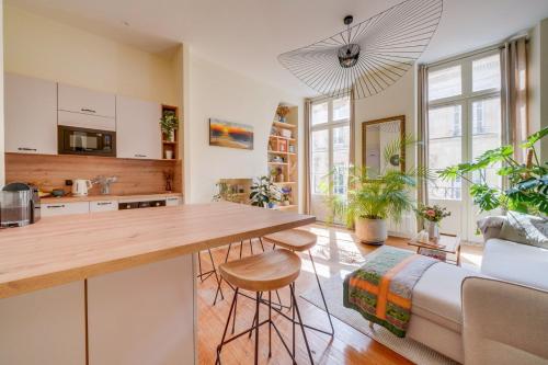 une cuisine et un salon avec une table et un canapé dans l'établissement Charmant appartement en plein cœur de Bordeaux, à Bordeaux