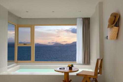 a room with a view of the ocean from a window at Shenzhen GuanHu Secret Wild Reef Seaview Hotel in Shenzhen