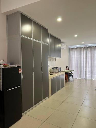 a kitchen with gray cabinets and a black refrigerator at Jomstay Guest House Melaka in Malacca