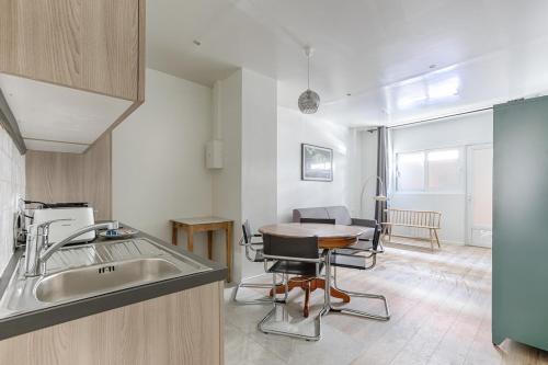 - une cuisine avec un évier et une table dans une chambre dans l'établissement Traversière III Boulogne-Billancourt Apartment4P, à Boulogne-Billancourt