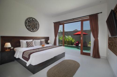 a bedroom with a bed and a large window at Bougainnvillea Villa Cemagi by Parigata in Cemagi
