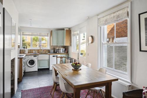 a kitchen with a wooden table and a dining room at Beautiful Victorian Home on Peaceful Green Square in Exeter