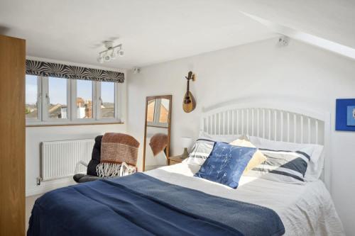 a bedroom with a blue and white bed and a chair at Beautiful Victorian Home on Peaceful Green Square in Exeter